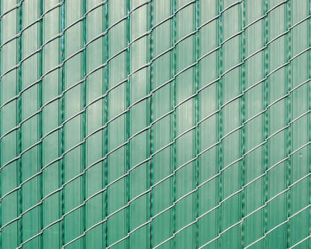 Green pattern of vertically oriented stripes of plastic woven with obliquely oriented wire -texture or backgroundの写真素材