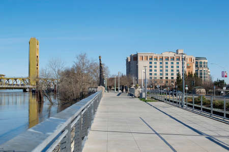 Sacramento, California, U.S.A. 12 February 2017. Sacramento Tower Bridge and the Matsui Waterfront Park in the morning, showing the high water levels of the Sacramento River after the heavy rainsのeditorial素材