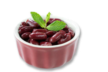 Closeup on red kidney beans in red bowl decorated with mint leaves on white background-healthy food...