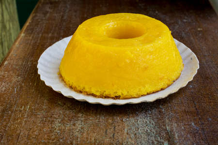 Closeup on quindim, a tasty yellow Brazilian dessert made with condensed milk and eggs on grunge wooden tableの写真素材