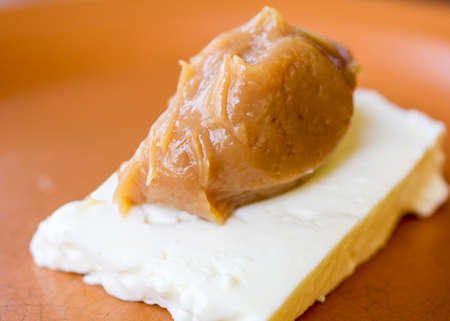 Closeup on  a serving of caramel cream (doce de leite) with white cheese (Queijo de Minas),  a...