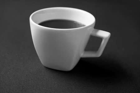 White cup of black coffee on black background - black and white renderingの写真素材