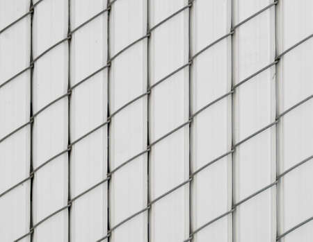 White pattern of vertically oriented chain-linked fence covered with plastic -texture or backgroundの写真素材