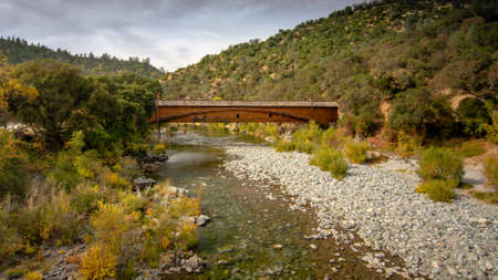 Side view of the bridgeport Covered Bridge at South Yuba River in California, USA, in the autumn. This bridge has the longest clear span of any surviving covered bridge in the worldのeditorial素材