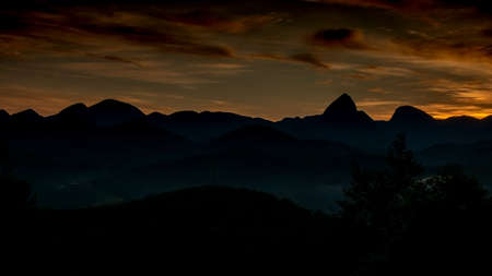 Panoramic view of Mountains of Itaipava, Petropolis, Rio de Janeiro, Brazil, in the sunrise, displaying warm colors and mountain silhouettesの写真素材