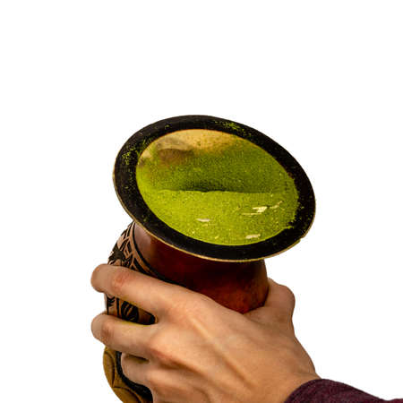 Hands holding a gourd container (cuia) after sifting and forming a half mate wall, as part of the process of making the chimarrao, a Brazilian traditional drink, isolated against white background, angle viewの写真素材