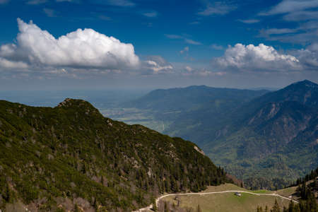 View from Herzogstand trail iin Upper Bavaria in the late Spring, featuring the valley below, green...