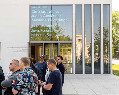 Munich, Bavaria, Germany - May 18, 2019. Tourists lisent to a presentation at the entrance of N-S...