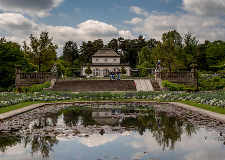 Munich, Bavaria, Germany - May 23, 2019.  MÃ¼nchen-Nymphenburg Botanical garden on a spring day featuring the entrance and the cafe, viewed from the back, and  a pondのeditorial素材