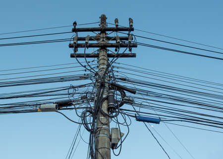 A mess of entangled electricity wires and pole, on a street in Brazilの写真素材