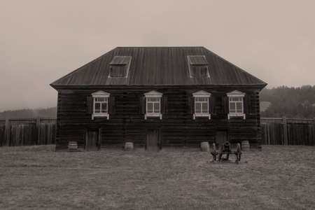 Old Building and canon at Fort Ross state park, a Russian Fort, on a foggy day, typical of the Sonoma Coast, California, USA in black and white with a sepia toneのeditorial素材