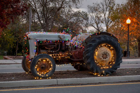 Winters, California, USA, Dec 6, 2019. Christmas. Rural town old, vintage Ford tractor decorated with Christmas lightsのeditorial素材