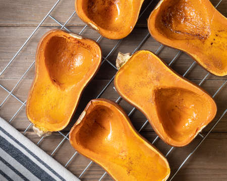 Fiive winter squash halves, roasted, on metal grill, vegan dish with cinammon and honey, Autumn harvest dessert conceptの写真素材