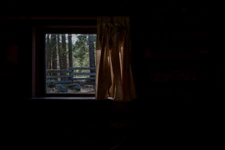 Looking through the window from inside log cabin view of wooden fence with plenty of copy-spaceの写真素材