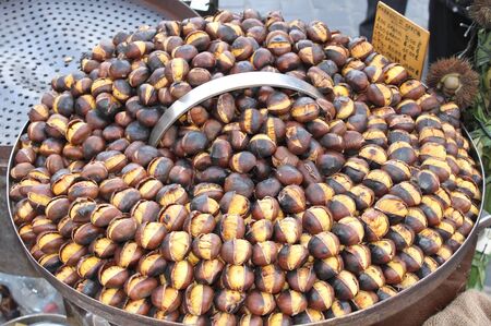 Grilled chestnuts for sale in a market stallの写真素材