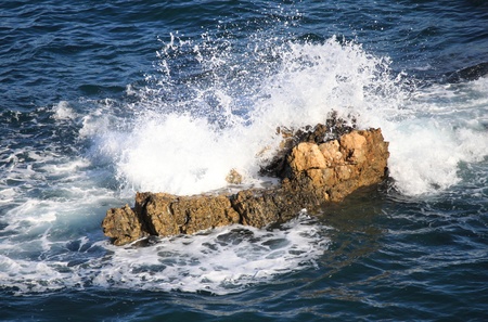 Ocean waves crushing against a cliff