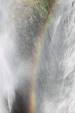 Rainbow created by a waterfallの写真素材