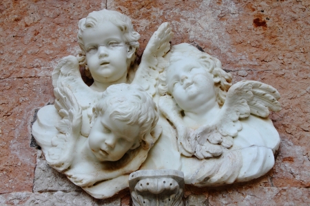 Basrelief from old building depicting three small angelsの写真素材