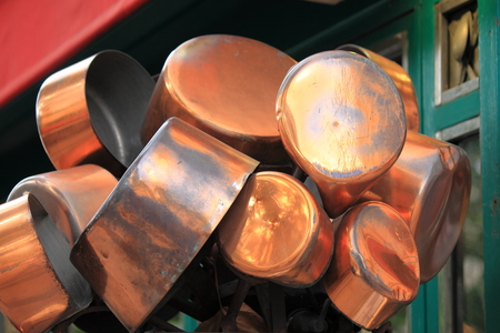 Copper pots hanging from the ceiling in the kitchenの写真素材