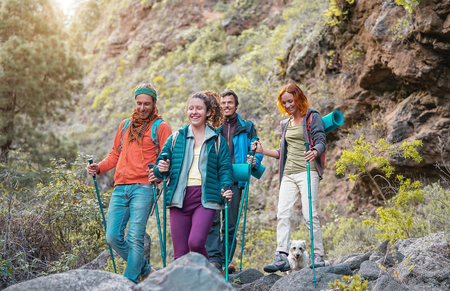 Group of friends with backpacks doing trekking excursion on mountain - Young  tourists walking and exploring the wild nature - Trekker, sport, hike and travel conceptの写真素材