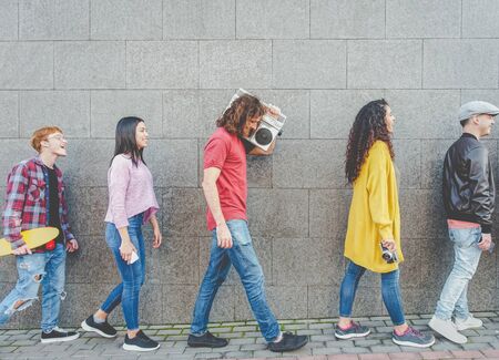 Happy friends walking together in the city center - Millennial trendy young people having fun doing...