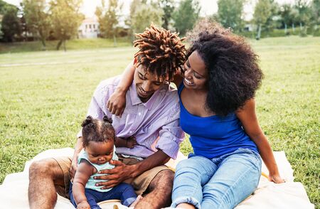 Happy African family spending time together during the weekend outdoor - Black mother and father...