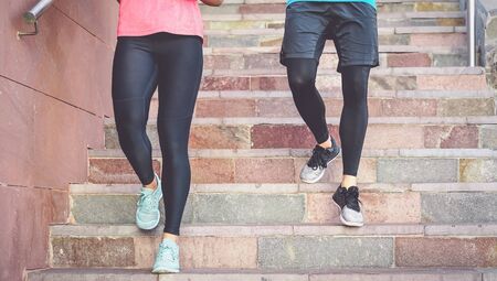 Fit couple doing steps workout session outdoor - Happy friends training running on stairs in city - Health people and sport lifestyle culture conceptの写真素材