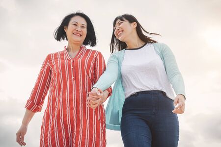 Happy Asian mother and daughter having fun outdoor - Chinese family spending time together outside - Love  relationship people and parenthood lifestyle conceptの写真素材