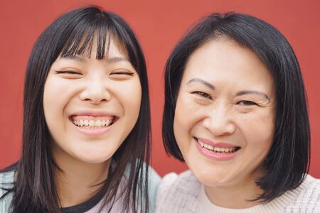 Happy Asian mother and daughter having fun outdoor -  Portrait Chinese family people spending time together outside - Love, relationship and parenthood lifestyle conceptの写真素材