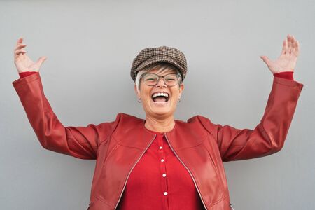 Happy senior woman dancing and laughing outdoor - Trendy mature person having fun during retired time - Elderly people lifestyle conceptの写真素材