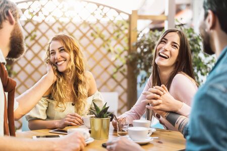Happy friends drinking cappuccino in cafeteria bar - Young romantic couple having fun sharing time together -  Love relationship and social gathering people lifestyle conceptの写真素材
