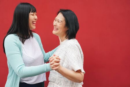 Happy Asian mother and daughter having fun outdoor - Chinese family people spending time together outside - Parents Relationship lifestyle and mother's day conceptの写真素材