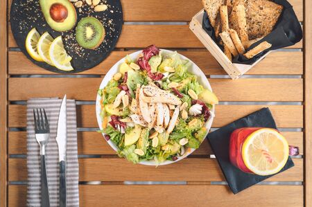 Top view health vegetable salad with chicken breast avocado kiwi and fresh smoothie fruits - Healthy brunch food lifestyle conceptの写真素材