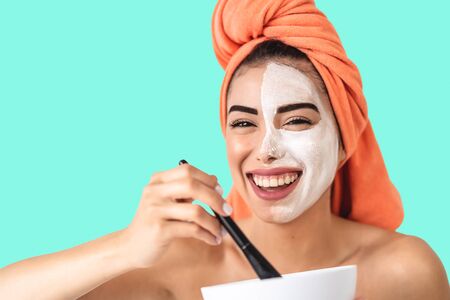 Happy girl applying daily facial cream - Young woman having skin care spa day - Healthy beauty clean...