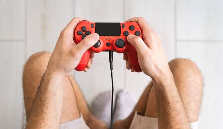 Young man playing online video games - Close up male hands gamer having fun on new technology...
