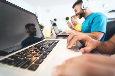 Young friends working together inside co-working space - Millennial people doing startup strategy in...