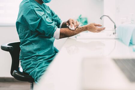 Surgeon washing hands before operating patient in hospital - Medical worker getting ready for fighting against corona virus pandemic - Health care and hygiene conceptの写真素材