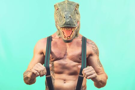 Fit senior man wearing t-rex dinosaur mask - Crazy hipster guy having fun celebrating masquerade...