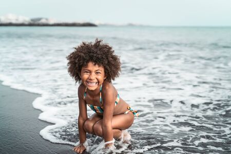 Afro American child having fun on the beach - Little kid playing during summer time outdoor - Black people and vacation conceptの写真素材