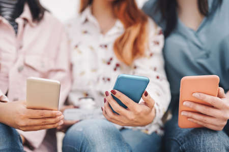Group friends using mobile smartphone outdoor - Millennial young people having fun with new social...