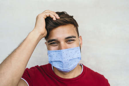 Young man wearing face mask portrait - Latin boy using protective facemask for preventing spread of corona virus - Health care and youth millennial people conceptの写真素材