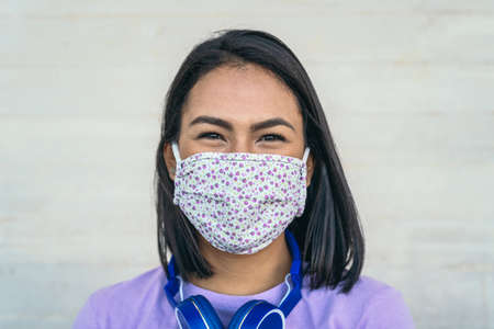 Young woman wearing face mask portrait - Latin girl using protective facemask for preventing spread of corona virus - Health care and pandemic crisis conceptの写真素材