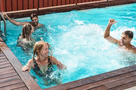 Young people having fun in exclusive pool party - Happy friends enjoying summer holidays in swimming...