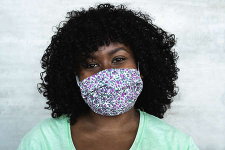 Happy African woman portrait - Afro girl wearing protective face mask for preventing spread of corona virus - Health care people conceptの写真素材