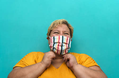Happy plus size woman wearing face mask portrait - Curvy overweight model having fun posing in front...