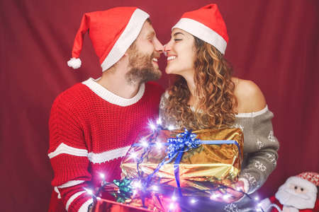 Happy couple celebrating Christmas time sharing presents - Young people having fun during x-mas...