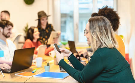 Young friends working together inside co-working creative space - Teamwork doing startup strategy in modern office - Youth millennial generation and technology conceptの写真素材