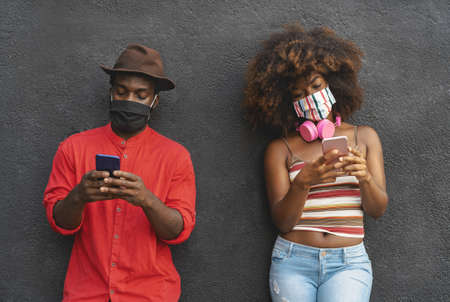 African friends using mobile smartphone during corona virus outbreak - Youth people addiction and technology conceptの写真素材