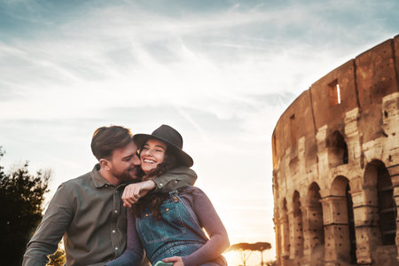 Young couple having positive emotions in Rome Colosseum - Happy lovers romantic moments during vacations in Italy - Love relationship and romance travel lifestyle conceptの写真素材