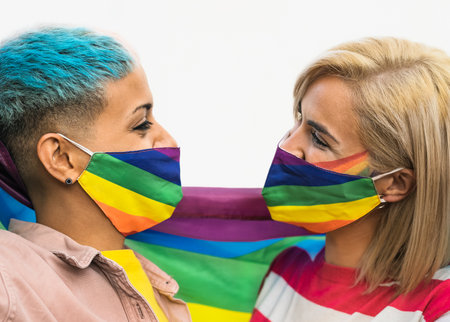 Happy gay couple wearing face mask celebrating gay pride event during corona virus pandemic - Homosexual love and LGBT conceptの写真素材